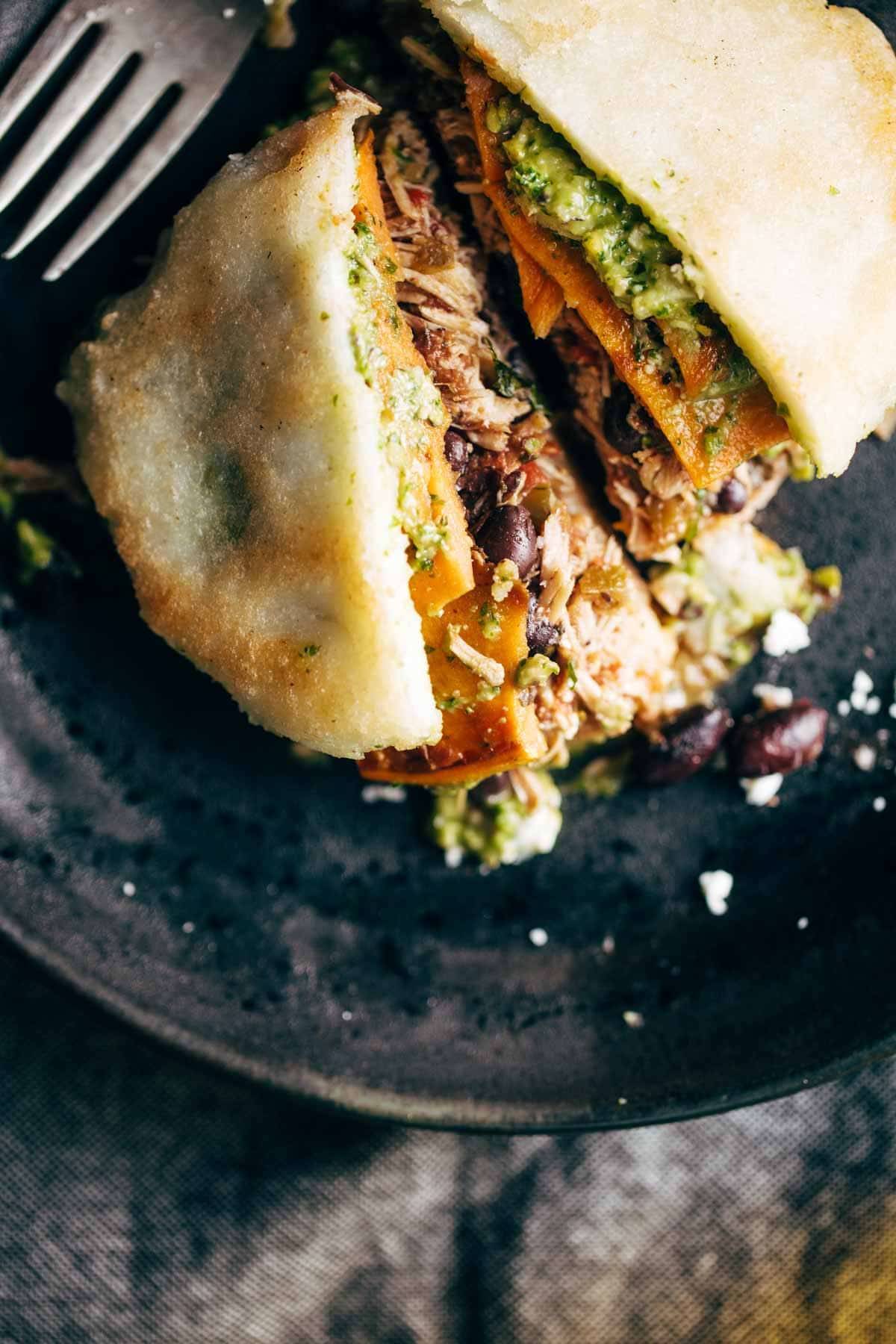 Arepas - fried cornmeal pockets stuffed with all the fillings you could ever want, like carnitas, spicy chicken, sweet potatoes, black beans, sauces, and more. THESE ARE SO GOOD! | pinchofyum.com