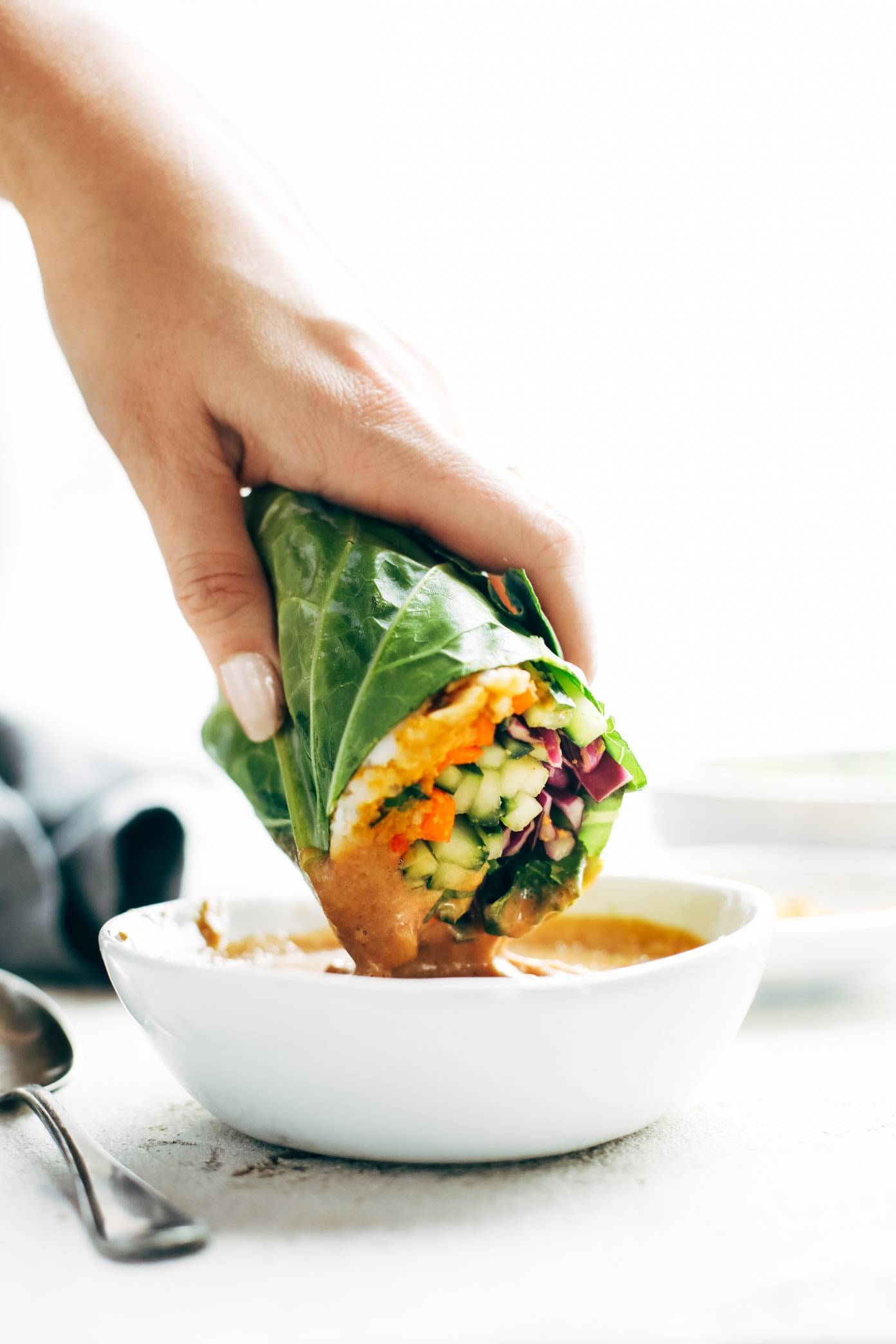 Detox Rainbow Roll-Ups - with curry hummus and veggies in a collard leaf, dunked in peanut sauce! most beautiful healthy desk lunch! | pinchofyum.com