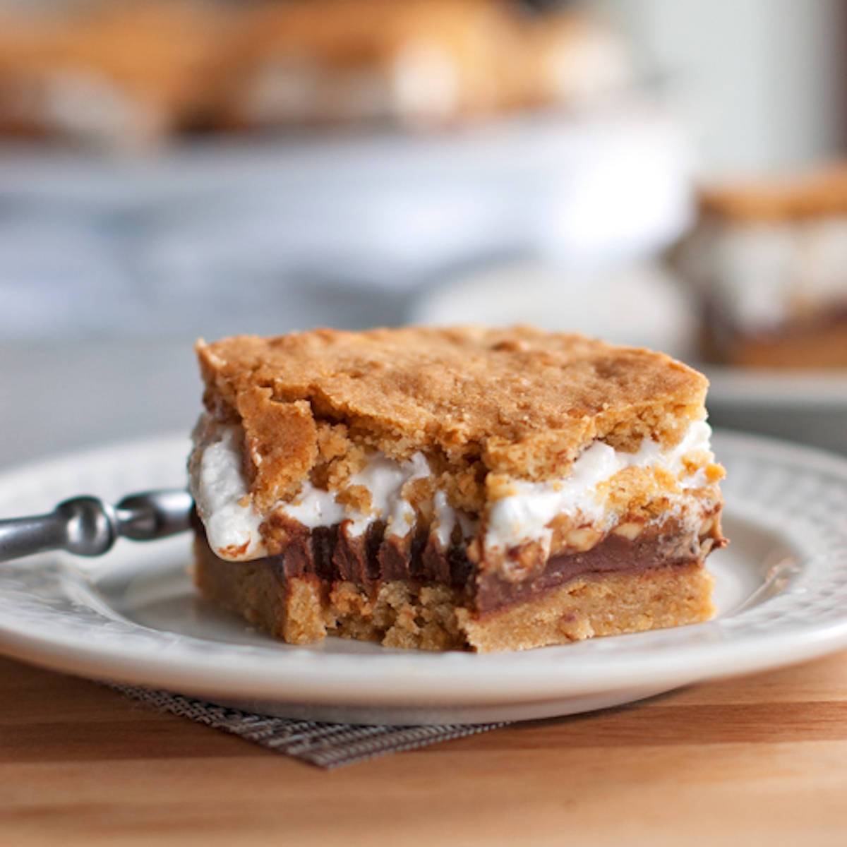 These s'mores bars have peanut butter layered in between marshmallow fluff, chocolate, and a graham cookie base. Just like s'mores! | pinchofyum.com